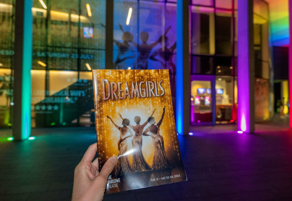 Dreamgirls programme outside The Marlowe Theatre at night, Canterbury