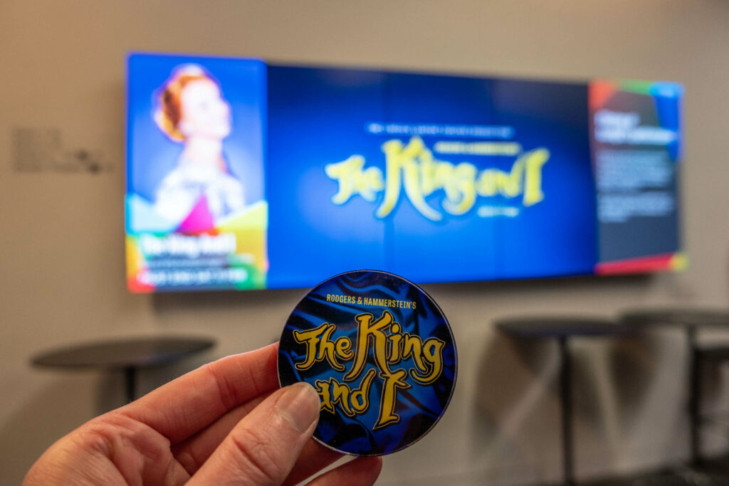 The King and I magnet in front of a digital poster for the production at The Marlowe Theatre, Canterbury