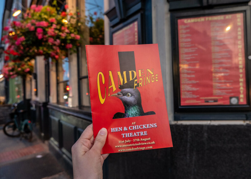 Camden Fringe programme in front of The Hen & Chickens Theatre
