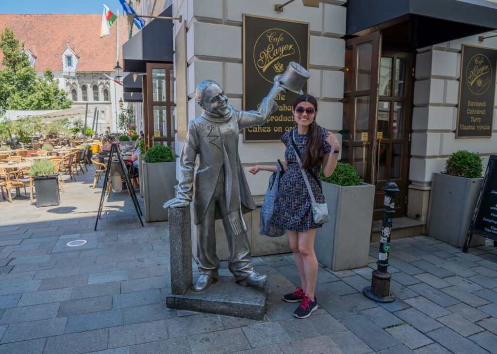 Kat Masterson standing next to a Bratislava city statue, Slovakia