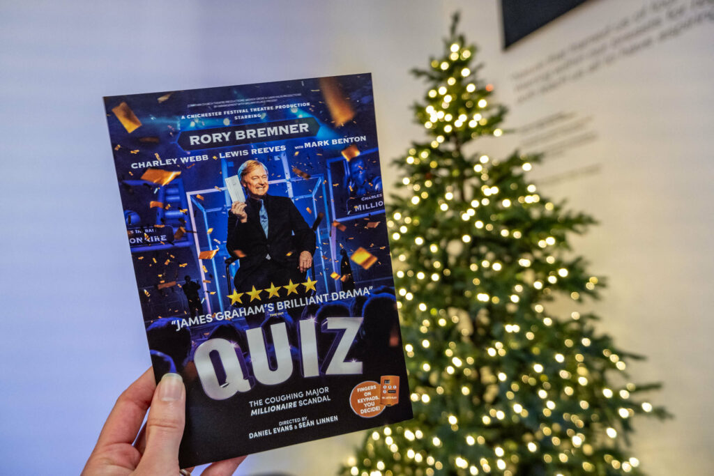 Quiz the play leaflet in front of The Marlowe Theatre's Christmas tree, Canterbury