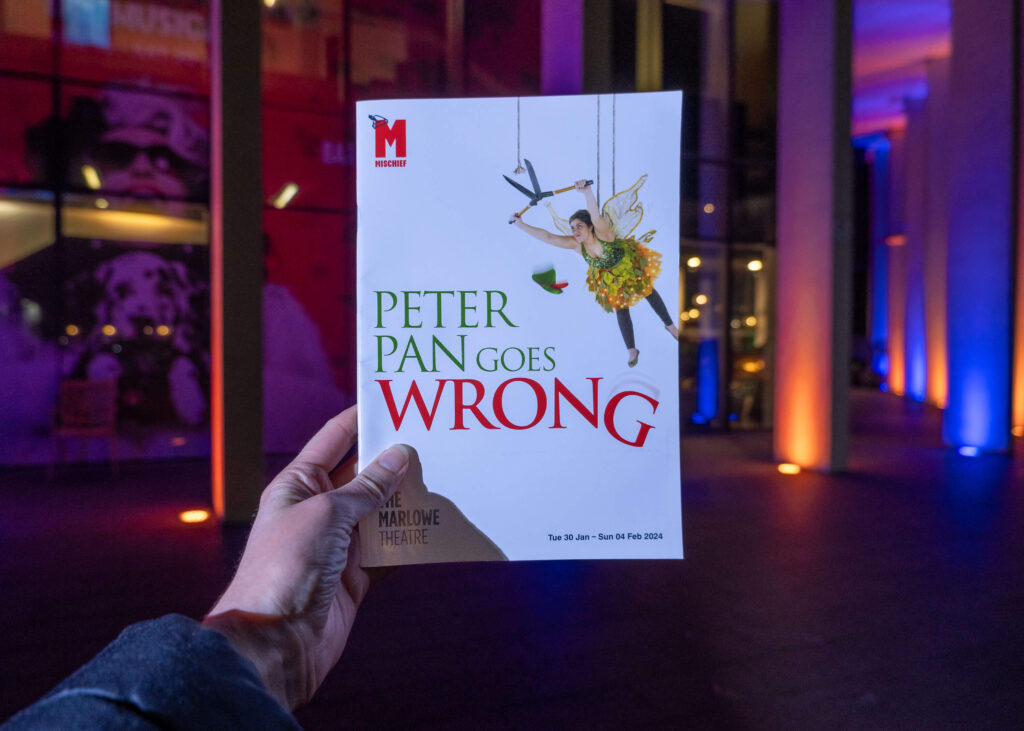 Peter Pan Goes Wrong programme outside The Marlowe Theatre, Canterbury