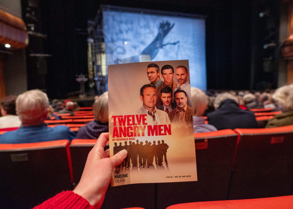 Twelve Angry Men programme in front of the stage at The Marlowe Theatre, Canterbury