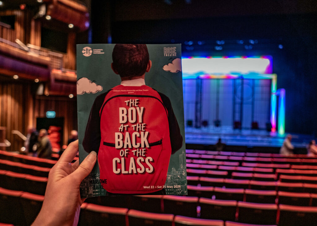 The Boy At The Back Of The Class programme in front of the finale staging at The Marlowe Theatre, Canterbury