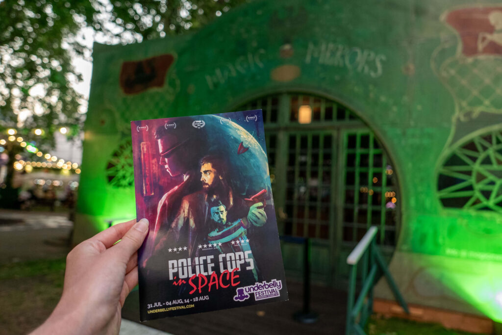 Police Cops in Space leaflet in front of the Spiegeltent at Underbelly Festival, Cavendish Square