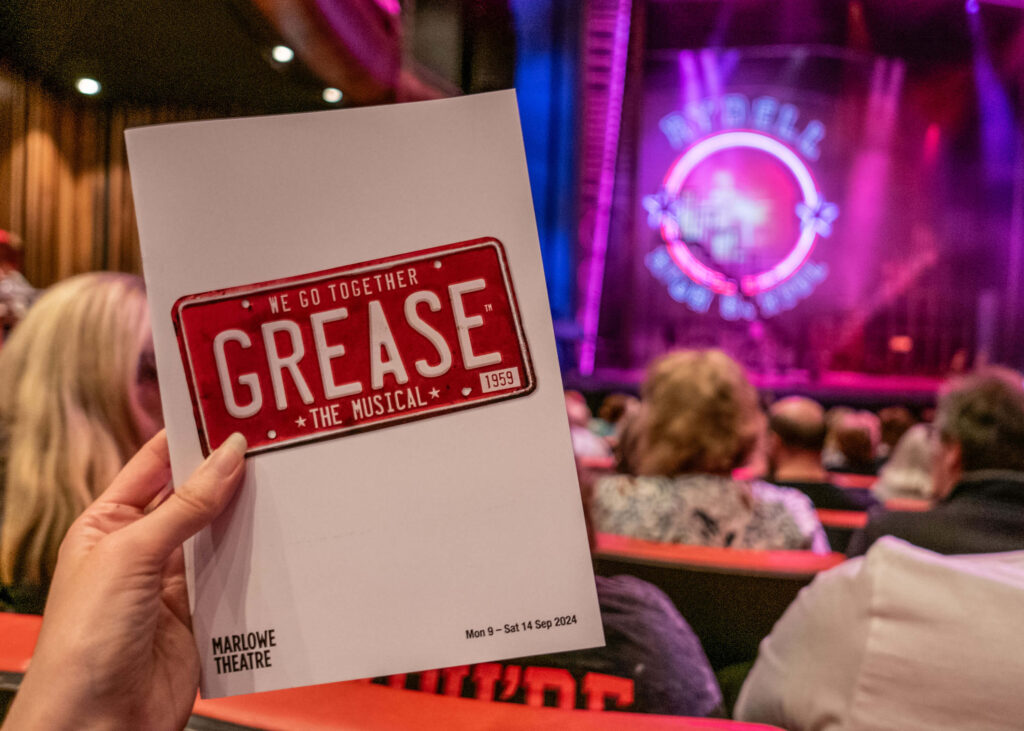 Grease the Musical programme in front of the Marlowe Theatre stage in Canterbury, Kent