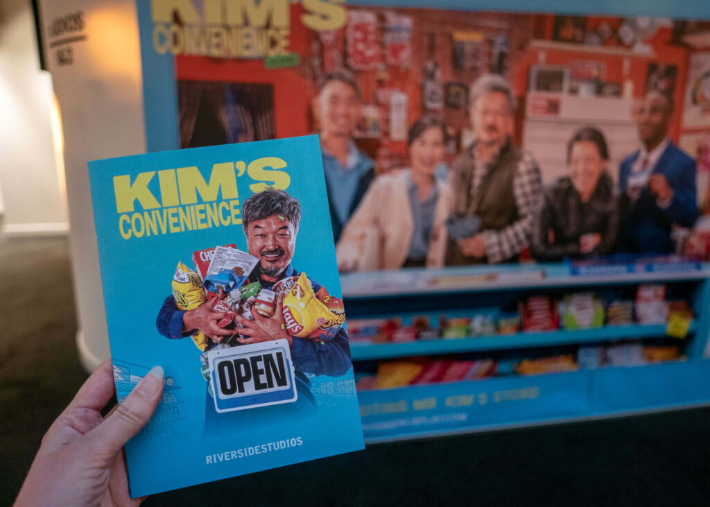 Kim's Convenience programme in front of the show artwork at Riverside Studios, London