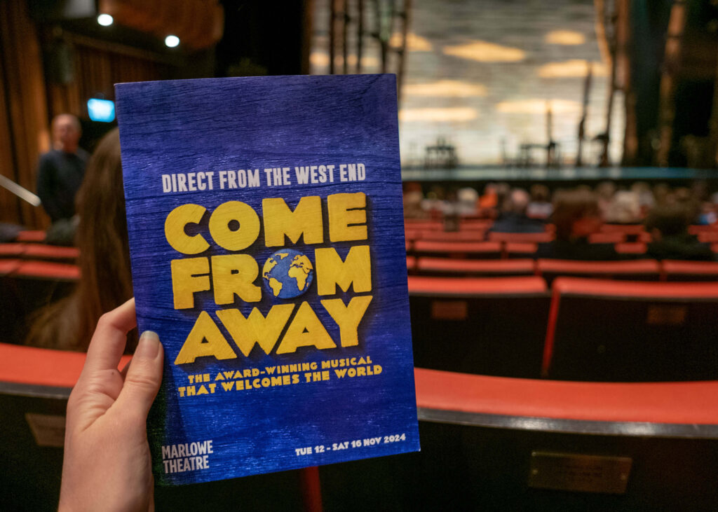 Come From Away programme in front of the Marlowe Theatre stage, Canterbury