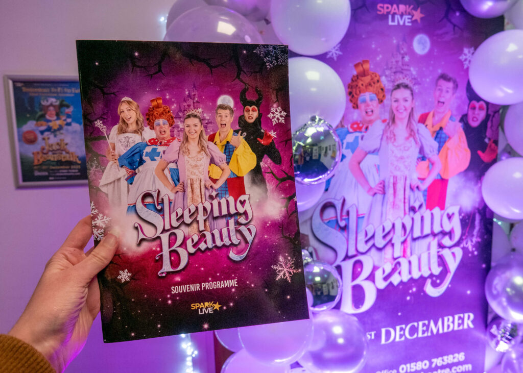 Sleeping Beauty (2024 Tenterden Panto) programme in front of the balloon arch at the Sinden Theatre