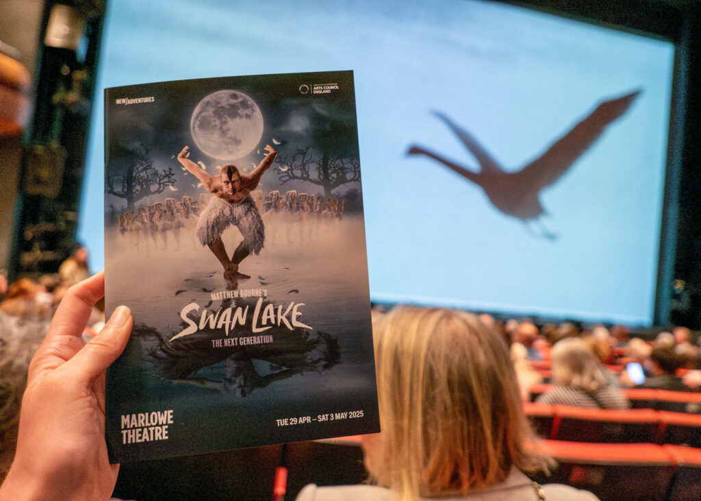 Matthew Bourne's Swan Lake programme in front of the Marlowe Theatre stage, Canterbury